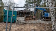 Omakotitalon purkutyömaalla työkone purkaa rakennusta kouralla.