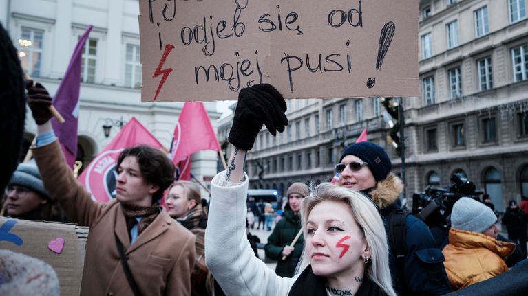 Mielenosoittajat pitelevät kylttejä kadulla.