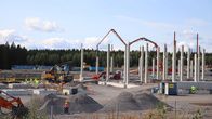 Datakeskuksen rakennustyömaa. Pilareita ja työkoneita.