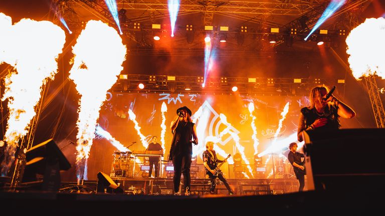 Blind Channel soittaa Ruisrockin rantalavalla kesällä 2022, lava täynnä pyrotekniikan tuottamia liekkileimahduksia.