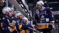 Jääkiekkoilijat hymyilevät toisilleen vaihtopenkillä. 