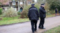 Poliisit seisovat maantiellä, taustalla näkyy rakennus.