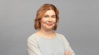 Minna Mustakallio yllään vaalea paita ja käsivarret ristissä