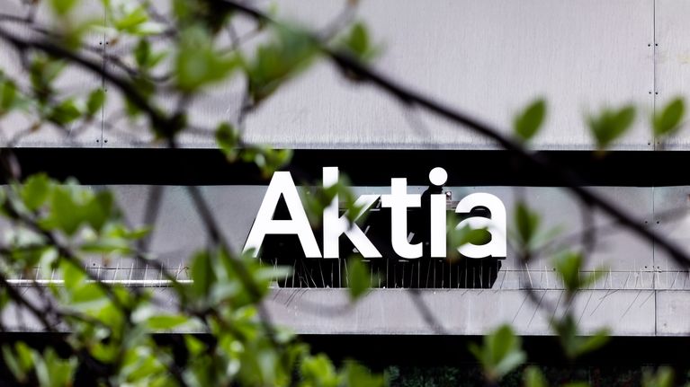 Aktia pankin kyltti toimistorakennuksen seinässä, etualalla puun lehtiä.