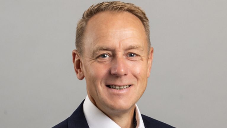 Porträttbild av man i kostym som ser rakt in i kameran.