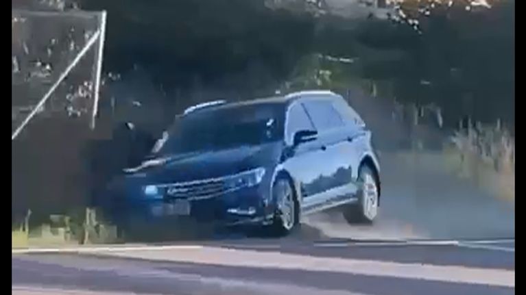 Sininen henkilöauto ajaa kovalla nopeudella päin mopoilijaa.