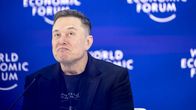 Elon Musk istuu lavalla, taustalla lukee World Economic Forum.