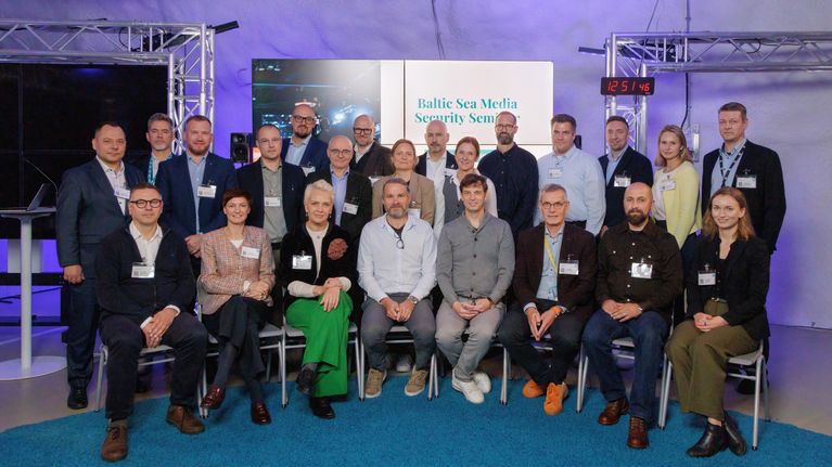 En grupp människor sitter, i bakgrunden syns en skärm med texten Baltic Sea Media Security Seminar.