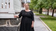Salla Maijala seisoo kivijalalla varustetun valkoisen puutalon edustalla kävelytien vieressä, taustalla puita ja kerrostaloja.