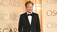 En man står på röda matten för Oscars.