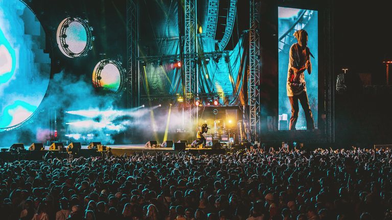 Asap Rocky täyteen ahtautuneen Blockfest-yleisömn edessä lavalla. Kuva on otettu kaukaa, oikean artistin vierellä näkyy hänen kuvansa screenillä moninkertaisena.