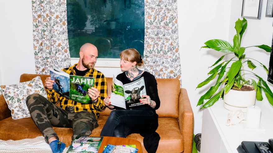 Tapio lukee Jahti-lehteä ja Kaisa Animalia-lehteä sohvalla.
