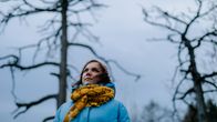 Anne Soudakova lähikuvassa, taustalla näkyy puiden oksia.