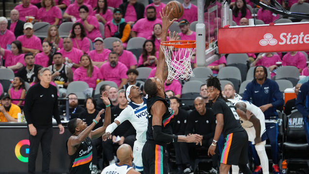 San Antonion Victor Wembanyama torjuu Minnesotan Jaden McDanielsin. Taustalla seuraa Timberwolvesin valmentaja Chris Finch.      