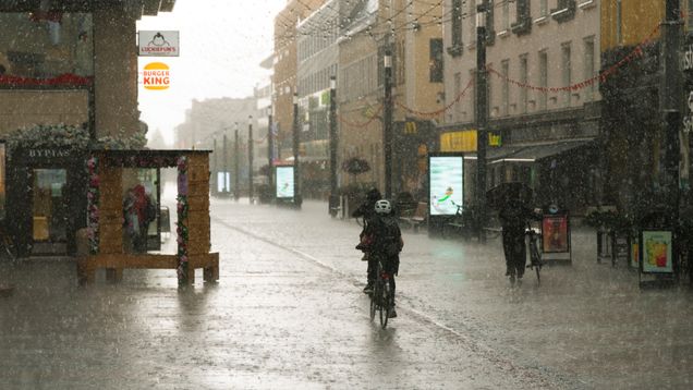 A cyclist in the rain. Burger king sign in the background.