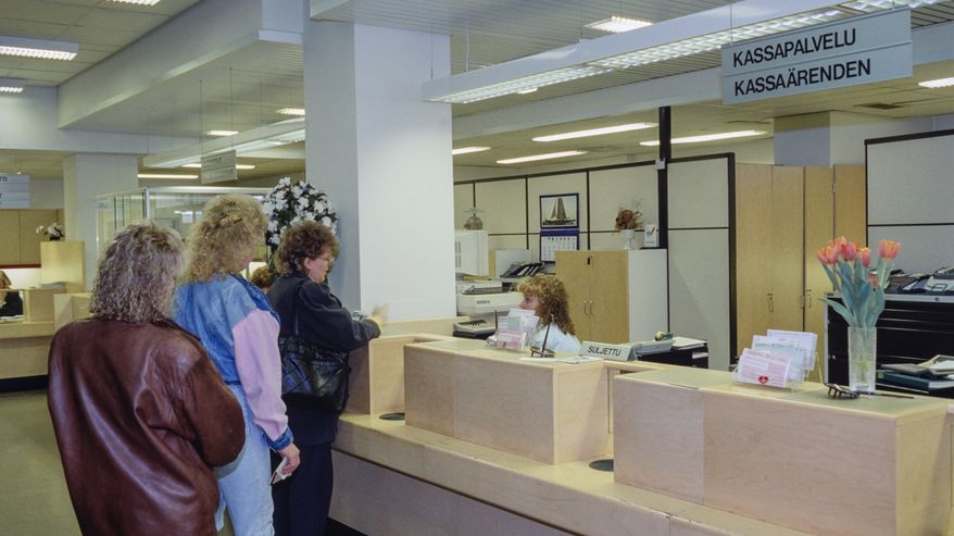 Ihmisiä jonottamassa pankin tiskille 1990-luvulla.