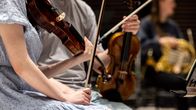 Orkesteri harjoittelee klassisen musiikin  kappaletta.