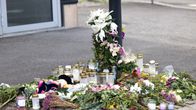 Blommor och ljus på en trottoar.