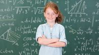 Flicka framför griffeltavla med matematiska uträkningar