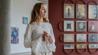 Valokuvataiteilija Ananya Tanttu seisoo teoksiensa edessä Taideyliopiston tiloissa.