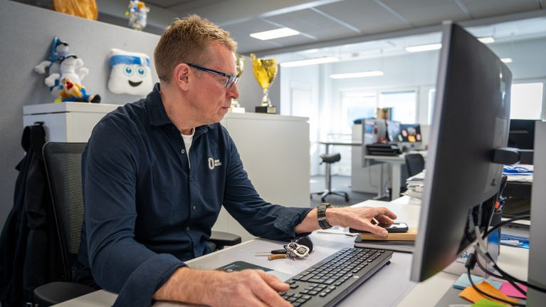 Suomen Urheiluliiton toimitusjohtaja Harri Aalto istuu tietokoneen äärellä.