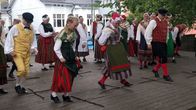 Folkdansare uppträder med dansen Skinkompassen på en scen.