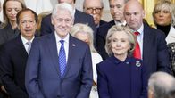Tummasinisiin pukeutuneet Bill ja Hillary Clinton, taustalla muista ihmisiä.