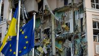 Ukrainan ja Eu:n liput tuhoutuneen hotellirakennuksen edessä Kiovassa.