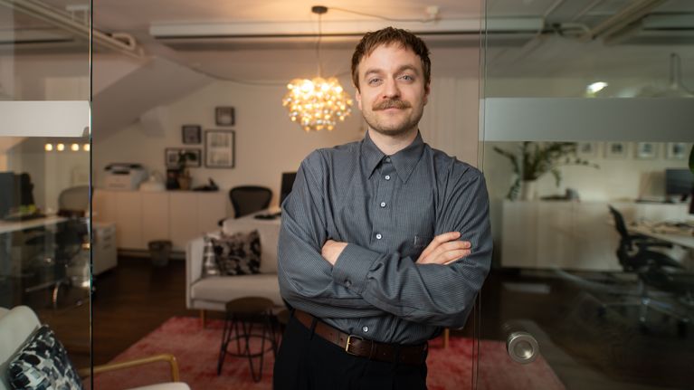 En man fotograferas i ett rum.