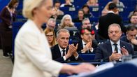 Euroopan parlamentin istuntosalissa henkilö puhuu puhujakorokkeella, taustalla istuu ja taputtaa useita ihmisiä.