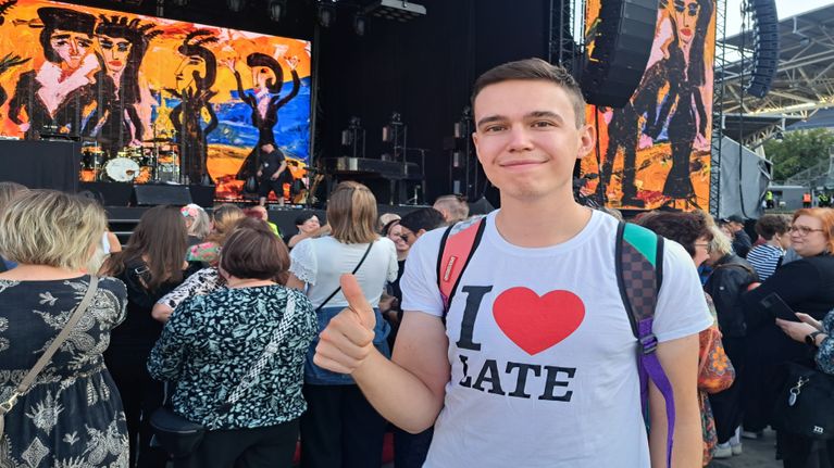 Lauri Tähkän fani poseeraa kameralle esiintymislavan edessä.