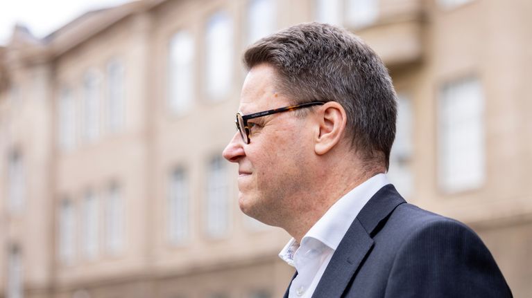 Petri Rouvinen ulkona sininen puku päällä.