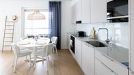 A Scandinavian-style kitchen, featuring light wood and white surfaces.