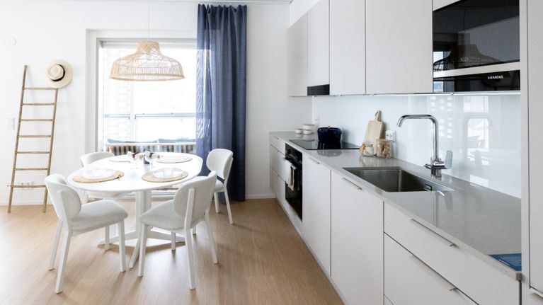 A Scandinavian-style kitchen, featuring light wood and white surfaces.