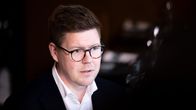 Antti Lindtman tummassa taustassa katsoen oikealle.