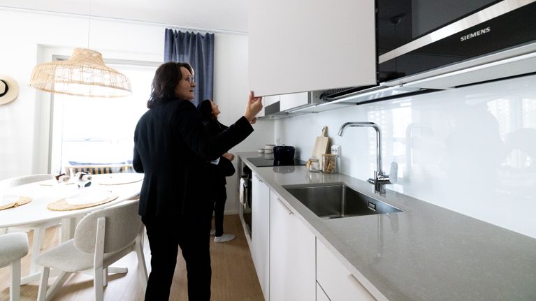 Two people inspecting a kitchen at an apartment viewing. 