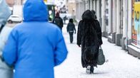 Människor går på en snöig gata.