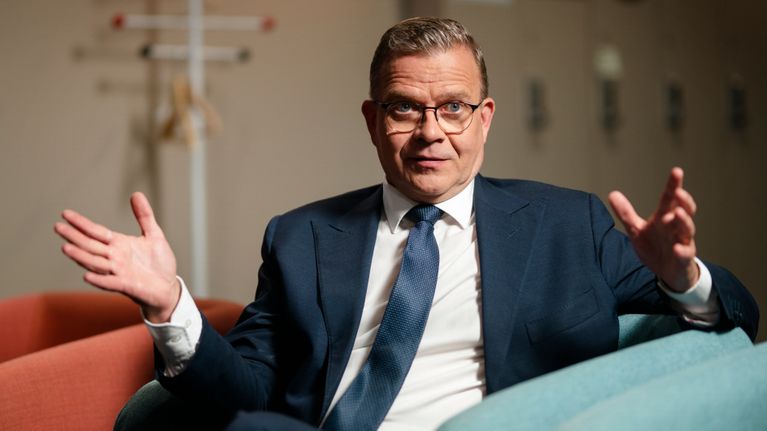 Petteri Orpo istuu nojatuolissa Ylen lämpiössä ja puhuu käsillään elehtien.