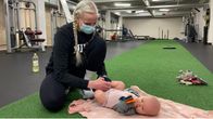 Äiti Laura Lehtilä vaihtaa vaippoja vauvalleen kuntosalin lattialla. 