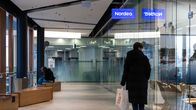 Henkilö kävelee Nordean pankin ikkunoiden ohi.