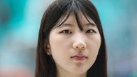 En sydkoreansk ung kvinna i närbild. Bakgrunden går inte att urskilja men är ljusblå till färgen.