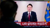 Etelä-Korean presidentti Yoon Suk-yeol puhuu televisiossa. Etualalla oikealla näkyy ihmisen hahmo katsomassa lähetystä.