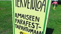 Nurmikolla seisoo kyltti, joka kutsuu ilmaiseen Parafest-tapahtumaan.