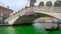 En kanal i Venedig där vattnet är grönt.