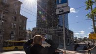 En man tittar på en skadad skyskrapa i Kievs centrum efter ryska bombningar.