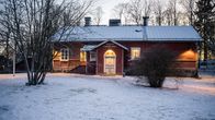 En skolbyggnad i rött trä. På byggnaden står det "Bibliotek & Kyrkoby skola". 