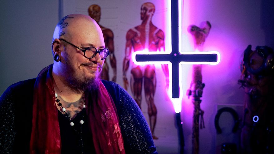 Henri Hiljander hymyilee väärinpäin roikkuvan valoristin vieressä.