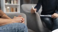 Två personer sitter i varsin fåtölj under en terapisession. Personernas huvuden och ansikten finns inte med i bilden.