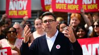 Andy Burnham fotograferad i samband med en valkampanj. I bakgrunden anhängare med röd-vit-gula plakat med texten: "Andy, Vote Hope".