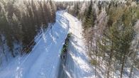 Ilmakuvassa joukko ihmisiä kävelee lumisella tiellä.
